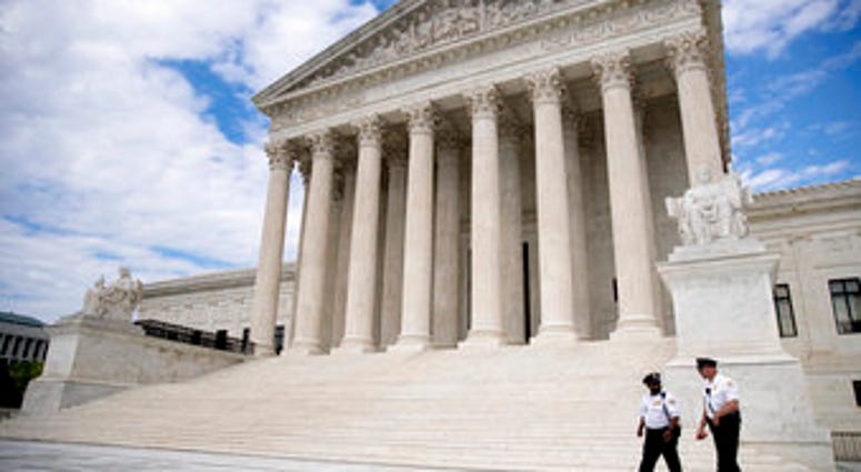 Security officers, one wearing a mask, walk in front of the Supreme Court, Thursday, May 14, 2020, in Washington. (AP Photo/Andrew Harnik) Security officers, one wearing a mask, walk in front of the Supreme Court, Thursday, May 14, 2020, in Washington. (AP Photo/Andrew Harnik)