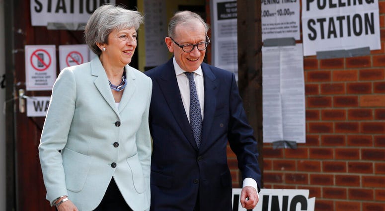 Britain's Prime Minister Theresa May and her husband Philip leave a polling station after voting in the European Elections in Sonning, England, Thursday, May 23, 2019. (AP Photo/Frank Augstein)