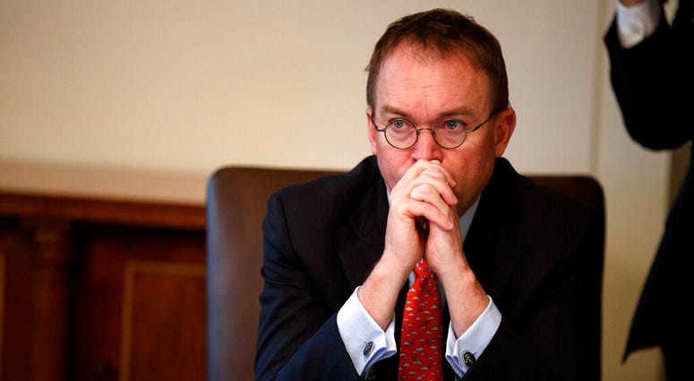 FILE- In this Jan. 2, 2019, file photo White House chief of staff Mick Mulvaney listens as President Donald Trump speaks during a cabinet meeting at the White House in Washington. Mulvaney says Trump is prepared for another government shutdown if Congress