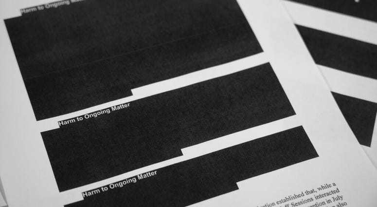 Special counsel Robert Mueller's report, with redactions, as released on Thursday, April 18, 2019, is photographed in Washington. (AP Photo/Jon Elswick)
