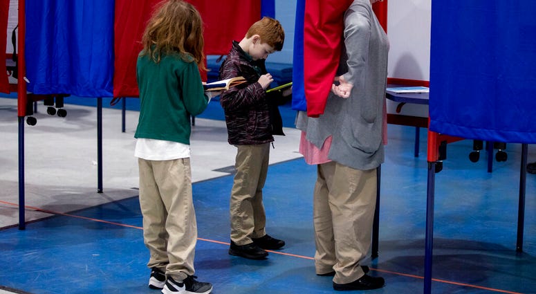 Samantha Murch accompanied by her two boys Alexander, 8, center, and Jacob, 11, left, votes in the New Hampshire primary at Bishop O'Neill Youth Center, Tuesday, Feb. 11, 2020, in Manchester, N.H. (AP Photo/Andrew Harnik) Samantha Murch accompanied by her two boys Alexander, 8, center, and Jacob, 11, left, votes in the New Hampshire primary at Bishop O'Neill Youth Center, Tuesday, Feb. 11, 2020, in Manchester, N.H. (AP Photo/Andrew Harnik)