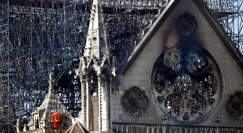 A fire fighter makes his way on a balcony of Notre Dame cathedral Wednesday, April 17, 2019 in Paris. French President Emmanuel Macron ratcheted up the pressure by setting a five-year deadline to restore the 12th-century landmark. (AP Photo/Francois Mori)
