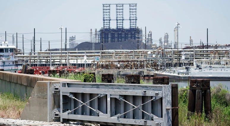 A flood gate and seawall that will be increased in size, is shown near a refinery Thursday, July 26, 2018, in Port Arthur, Texas. The oil industry wants the government to help protect some of its facilities. (AP Photo/David J. Phillip)