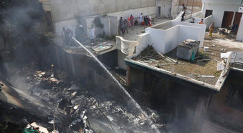 Fire brigade staff try to put out fire caused by plane crash in Karachi, Pakistan, Friday, May 22, 2020. (AP Photo/Fareed Khan) Fire brigade staff try to put out fire caused by plane crash in Karachi, Pakistan, Friday, May 22, 2020. (AP Photo/Fareed Khan)