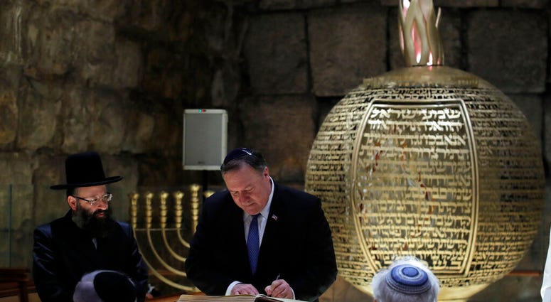U.S. Secretary of State Mike Pompeo signs a guest book during a visit together with Israeli Prime Minister Benjamin Netanyahu and U.S. Ambassador to Israel David Friedman in Jerusalem's Old City, March 21, 2019. (Jim Young/Pool Image via AP)