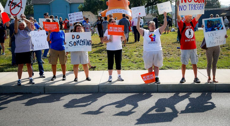 People gather to protest the arrival of President Donald Trump outside Miami Valley Hospital after a mass shooting that occurred in the Oregon District early Sunday morning, Wednesday, Aug. 7, 2019, in Dayton, Ohio. (AP Photo/John Minchillo)