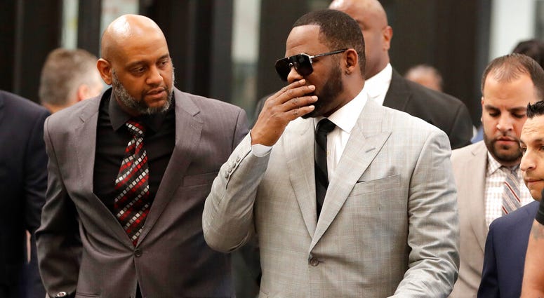 Musician R. Kelly, right, arrives at the Leighton Criminal Court building for an arraignment on new sex-related felonies Thursday, June 6, 2019, in Chicago. (AP Photo/Charles Rex Arbogast)