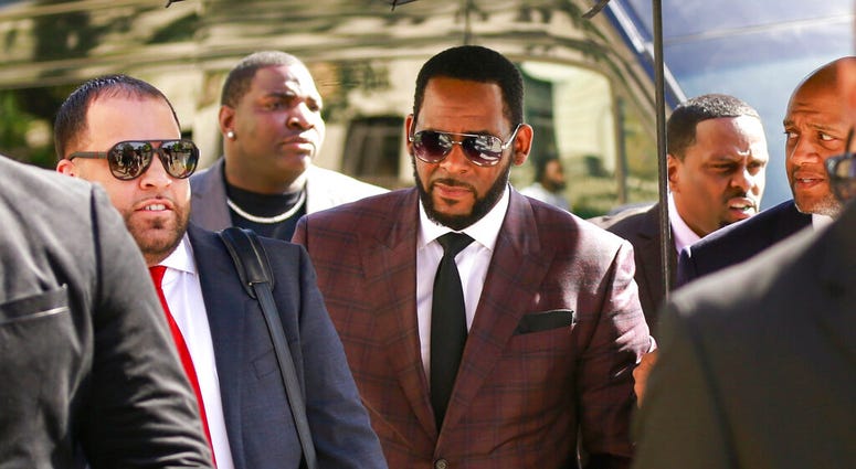 FILE - In this June 26, 2019, file photo, R&B singer R. Kelly, center, arrives at the Leighton Criminal Court building for an arraignment on sex-related felonies in Chicago. (AP Photo/Amr Alfiky, File)