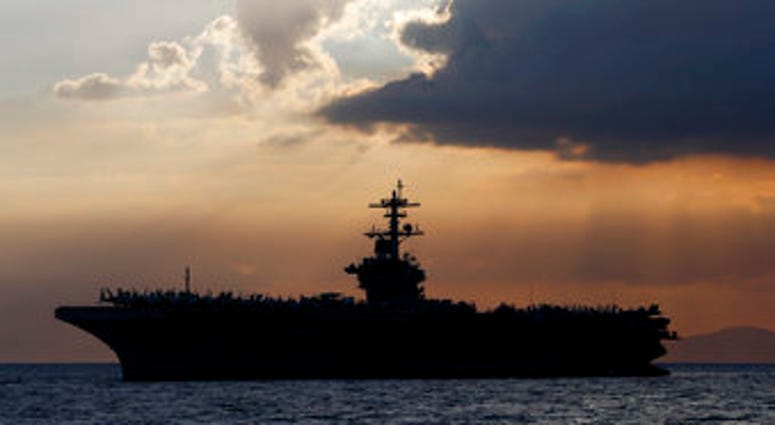 FILE - In this April 13, 2018, file photo the USS Theodore Roosevelt aircraft carrier is anchored off Manila Bay west of Manila, Philippines. (AP Photo/Bullit Marquez, File) FILE - In this April 13, 2018, file photo the USS Theodore Roosevelt aircraft carrier is anchored off Manila Bay west of Manila, Philippines. (AP Photo/Bullit Marquez, File)