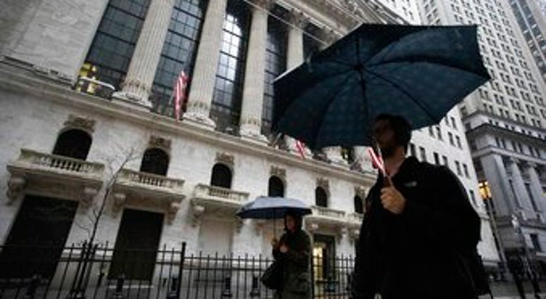 People walk in the rain as they pass the the New York Stock Exchange, Friday, March 13, 2020. (AP Photo/Mark Lennihan) People walk in the rain as they pass the the New York Stock Exchange, Friday, March 13, 2020. (AP Photo/Mark Lennihan)
