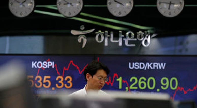 A currency trader walks by screens showing the Korea Composite Stock Price Index (KOSPI), left, and the foreign exchange rate between U.S. dollar and South Korean won at the foreign exchange dealing room in Seoul, South Korea. (AP Photo/Lee Jin-man) A currency trader walks by screens showing the Korea Composite Stock Price Index (KOSPI), left, and the foreign exchange rate between U.S. dollar and South Korean won at the foreign exchange dealing room in Seoul, South Korea. (AP Photo/Lee Jin-man)