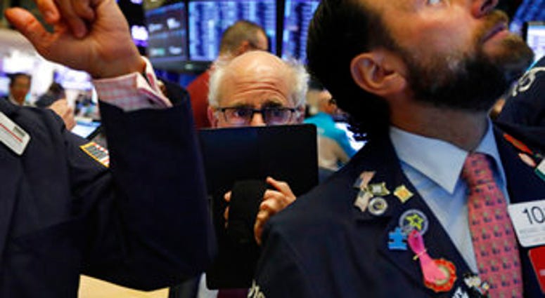 Trader Peter Tuchman, center, works on the floor of the New York Stock Exchange, Monday, Nov. 4, 2019. Stocks are opening higher on Wall Street, pushing major indexes toward more record highs. (AP Photo/Richard Drew)