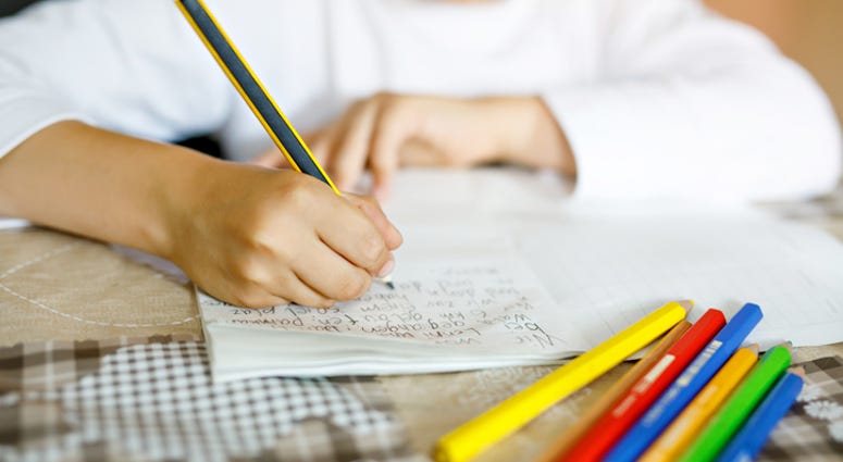 Child doing homework and writing story essay. (Stock photo - iStock / Getty Images Plus)