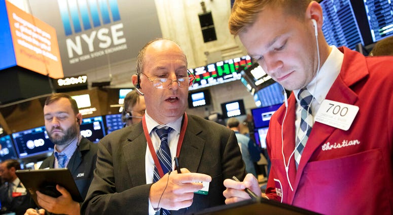 FILE - In this Sept. 16, 2019, file photo Gordon Charlop, center, and Christian Bader work at the New York Stock Exchange. The U.S. stock market opens at 9:30 a.m. EDT on Friday, Sept. 20. (AP Photo/Mark Lennihan, File)