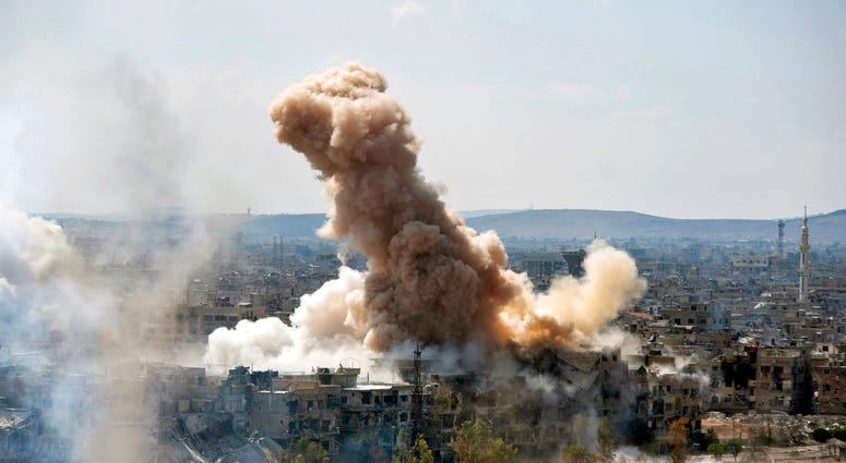 FILE - In this file photo released on Sunday, April 22, 2018 by the Syrian official news agency SANA, smoke rises after Syrian government airstrikes and shelling hit in Hajar al-Aswad neighborhood held by Islamic State militants, southern Damascus, Syria.