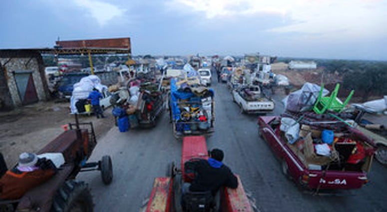 Truckloads of civilians flee a Syrian military offensive in Idlib province on the main road near Hazano, Syria, Tuesday, Dec. 24, 2019. (AP Photo/Ghaith al-Sayed) Truckloads of civilians flee a Syrian military offensive in Idlib province on the main road near Hazano, Syria, Tuesday, Dec. 24, 2019. (AP Photo/Ghaith al-Sayed)