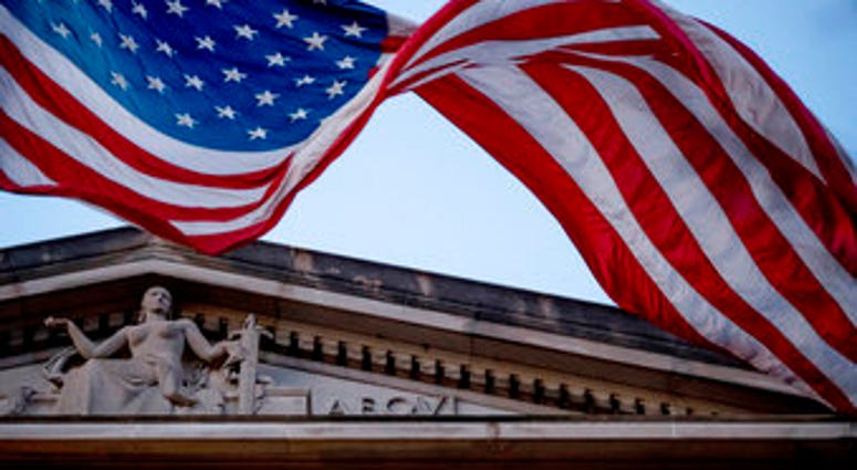 FILE - In this March 22, 2019 file photo, an American flag flies outside the Department of Justice in Washington. (AP Photo/Andrew Harnik)