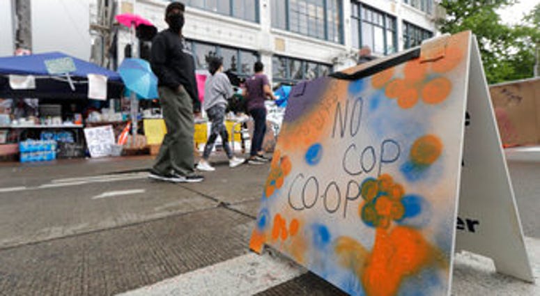People walk near what is being called the "No Cop Co-op" were protesters and others can get free food and other supplies, Thursday, June 11, 2020, inside what is being called the "Capitol Hill Autonomous Zone" in Seattle. (AP Photo/Ted S. Warren) People walk near what is being called the "No Cop Co-op" were protesters and others can get free food and other supplies, Thursday, June 11, 2020, inside what is being called the "Capitol Hill Autonomous Zone" in Seattle. (AP Photo/Ted S. Warren)
