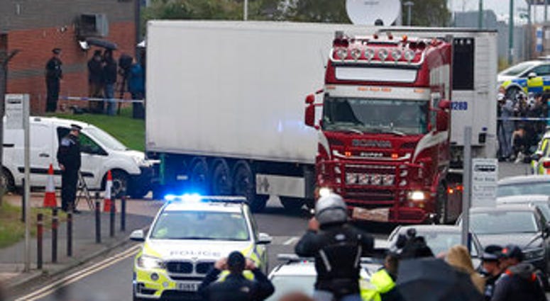 Police escort the truck, that was found to contain a large number of dead bodies, as they move it from an industrial estate in Thurrock, south England, Wednesday Oct. 23, 2019. (AP Photo/Alastair Grant)