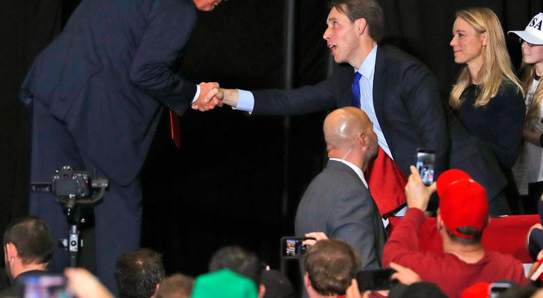 President Donald Trump shakes hands with Republican Senate candidate Josh Hawley at the end of a campaign rally Nov. 5, 2018. (AP Photo/Jeff Roberson)