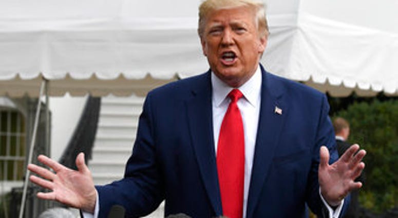 In this Oct. 25, 2019, photo, President Donald Trump talks to reporters on the South Lawn of the White House in Washington.