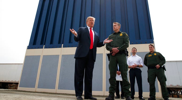 FILE - In this March 13, 2018, file photo, President Donald Trump talks with reporters as he reviews border wall prototypes in San Diego. (AP Photo/Evan Vucci, File)
