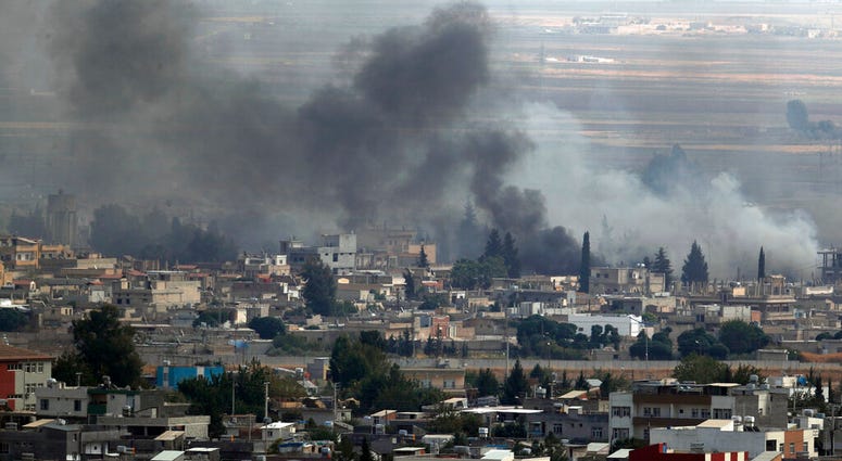 In this photo taken from the Turkish side of the border between Turkey and Syria, in Ceylanpinar, Sanliurfa province, southeastern Turkey, smoke billows from targets in Ras al-Ayn, Syria, during bombardment by Turkish forces. (AP Photo/Lefteris Pitarakis)