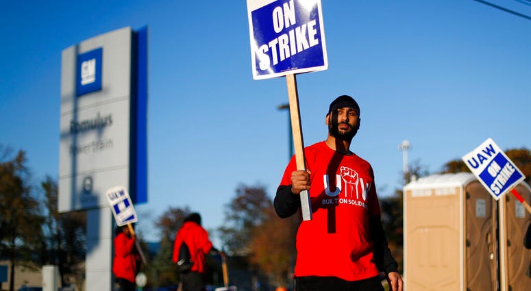 FILE - In this Oct. 9, 2019, file photo a member of the United Auto Workers walks the picket line at the General Motors Romulus Powertrain plant in Romulus, Mich. (AP Photo/Paul Sancya, File)