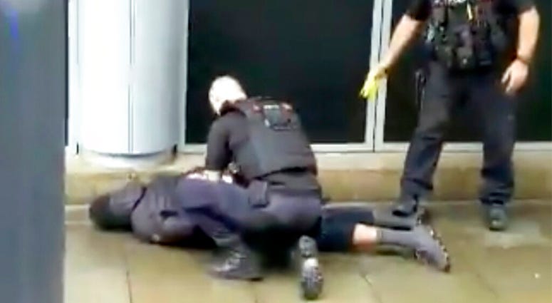 In this image taken from mobile phone footage, police arrest a man outside the Arndale Centre in Manchester, England, Friday October 11, 2019, after a stabbing incident at the shopping center that left four people injured. (John Greenhalgh via AP)