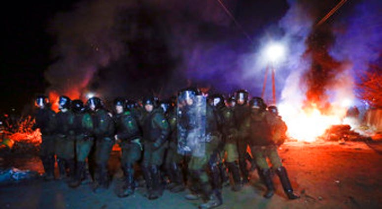 Ukrainian riot police prepare to push back protesters, who planned to stop buses carrying passengers evacuated from the Chinese city of Wuhan, outside Novi Sarzhany, Ukraine, Thursday, Feb. 20, 2020. (AP Photo/Efrem Lukatsky) Ukrainian riot police prepare to push back protesters, who planned to stop buses carrying passengers evacuated from the Chinese city of Wuhan, outside Novi Sarzhany, Ukraine, Thursday, Feb. 20, 2020. (AP Photo/Efrem Lukatsky)