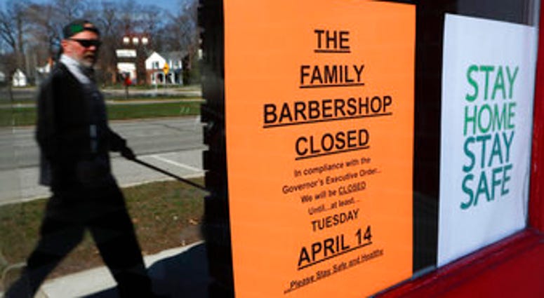 A pedestrian walks by The Family Barbershop, closed due to a Gov. Gretchen Whitmer executive order, in Grosse Pointe Woods, Mich., Thursday, April 2, 2020. (AP Photo/Paul Sancya) A pedestrian walks by The Family Barbershop, closed due to a Gov. Gretchen Whitmer executive order, in Grosse Pointe Woods, Mich., Thursday, April 2, 2020. (AP Photo/Paul Sancya)