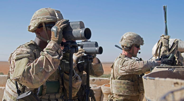 In this Nov. 1, 2018, photo released by the U.S. Army, soldiers surveil the area during a combined joint patrol in Manbij, Syria. (U.S. Army photo by Spc. Zoe Garbarino via AP)