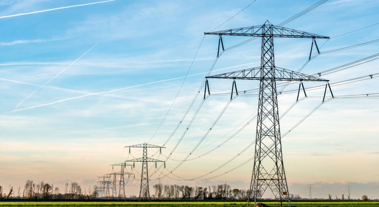 Overview of power pylons and high voltage lines in a long row in a rural landscape. (iStock / Getty Images Plus)