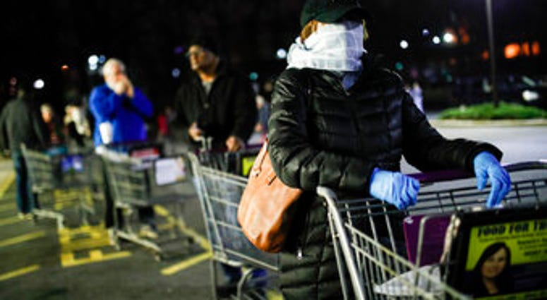 Customers wearing protective masks and gloves wait in line at a Stop & Shop supermarket that opened special morning hours to serve people 60-years and older due to coronavirus concerns. (AP Photo/John Minchillo) Customers wearing protective masks and gloves wait in line at a Stop & Shop supermarket that opened special morning hours to serve people 60-years and older due to coronavirus concerns. (AP Photo/John Minchillo)