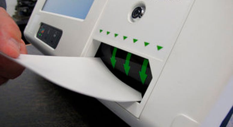 FILE - In this Aug. 16, 2019, file photo, a man feeds a ballot card into a digital voting machine during a demonstration in Raleigh, N.C. Americans have widespread concerns about the security and integrity of elections. (AP Photo/Allen G. Breed, File) FILE - In this Aug. 16, 2019, file photo, a man feeds a ballot card into a digital voting machine during a demonstration in Raleigh, N.C. Americans have widespread concerns about the security and integrity of elections. (AP Photo/Allen G. Breed, File)