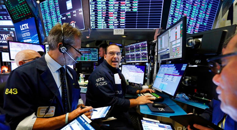 Specialist Anthony Matesic, center, works with traders at his post on the floor of the New York Stock Exchange, Wednesday, Aug. 21, 2019. (AP Photo/Richard Drew)
