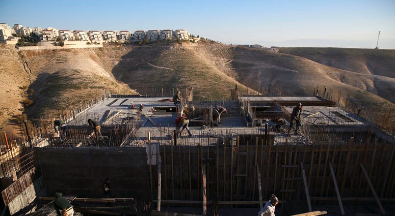 FILE - In this Feb. 7, 2017 file photo, Palestinian laborers work at a construction site in the Israeli settlement of Maale Adumim, near Jerusalem. (AP Photo/Oded Balilty, File)