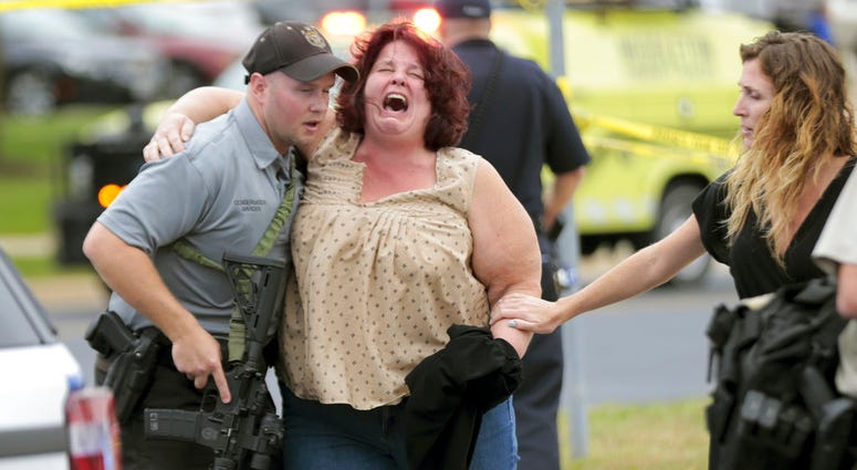 A women is escorted from the scene of a shooting at a software company in Middleton, Wis., Wednesday, Sept. 19, 2018. Four people were shot and wounded during the shooting in the suburb of Madison, according to a city administrator. (Steve Apps/Wisconsin