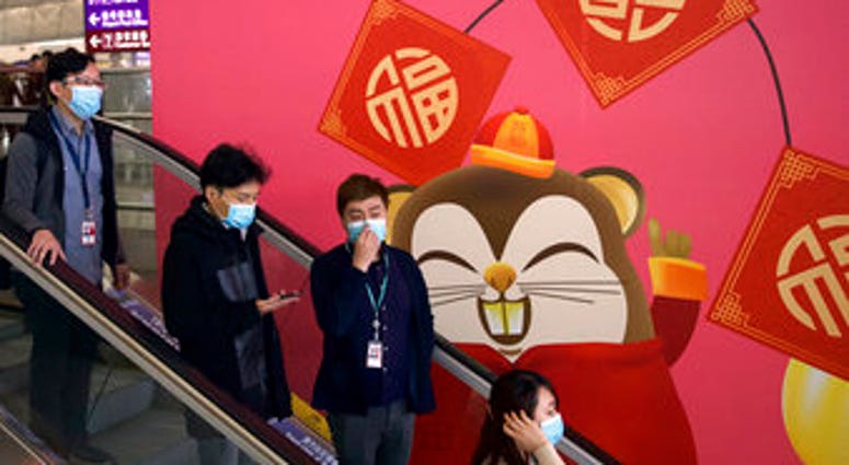 People wear face masks as they ride an escalator at the Hong Kong International Airport in Hong Kong, Tuesday, Jan. 21, 2020.(AP Photo/Ng Han Guan) People wear face masks as they ride an escalator at the Hong Kong International Airport in Hong Kong, Tuesday, Jan. 21, 2020.(AP Photo/Ng Han Guan)