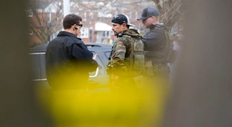 Law enforcement personnel work at the scene of a shooting, Wednesday, Feb. 12, 2020, in Baltimore. Two law enforcement officers with a fugitive task force were injured and a suspect died in the shooting. (Ulysses Muñoz/The Baltimore Sun via AP) Law enforcement personnel work at the scene of a shooting, Wednesday, Feb. 12, 2020, in Baltimore. Two law enforcement officers with a fugitive task force were injured and a suspect died in the shooting. (Ulysses Muñoz/The Baltimore Sun via AP)