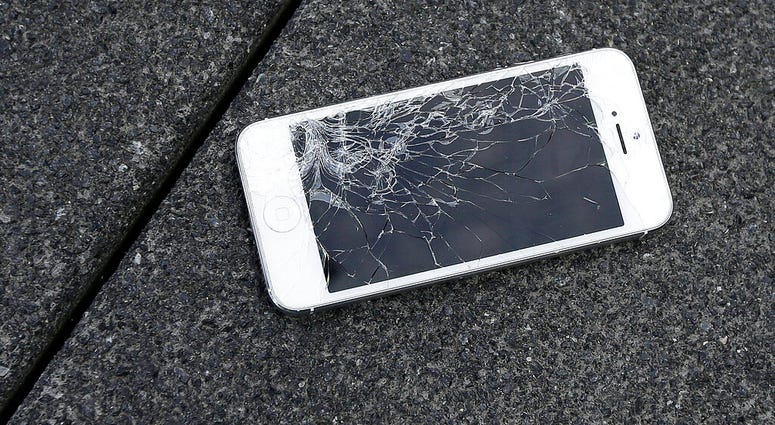 FILE - This Aug. 26, 2015 photo shows an Apple iPhone with a cracked screen after a drop test from the DropBot, a robot used to measure the sustainability of a phone to dropping. (AP Photo/Ben Margot, File)