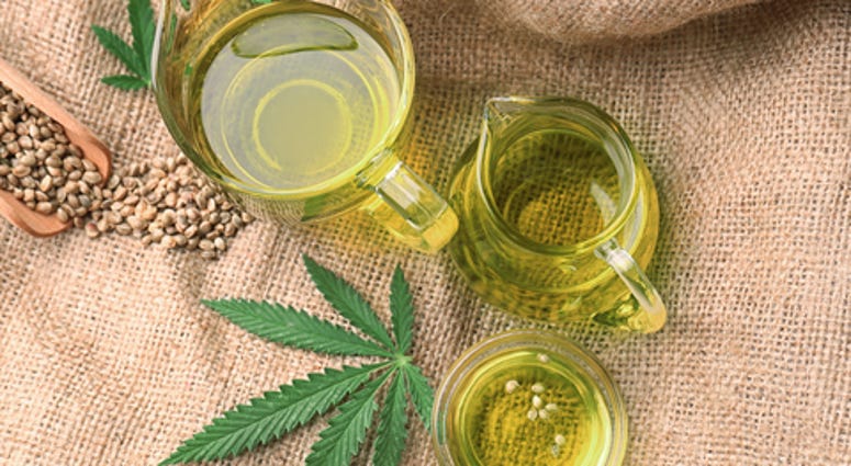 Composition with hemp oil in jugs on sackcloth