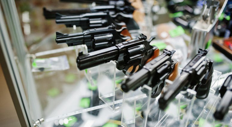 Different guns and revolvers on shelves store weapons on shop center