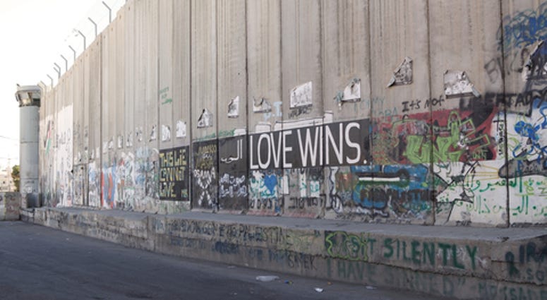 Love wins mural on the Israeli West Bank barrier near Bethlehem, Israel. The Israeli West Bank barrier is a security and separation barrier along and within the West Bank.