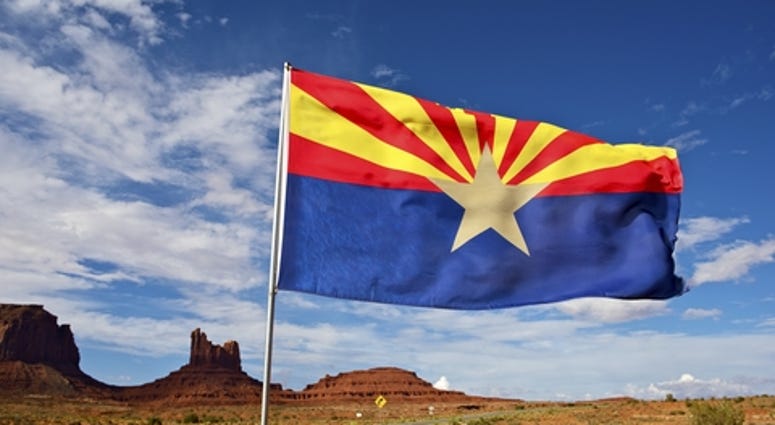 Arizona Flag on Wind. Arizona State Desert Landscape Near Monuments Valley, AZ, United States.