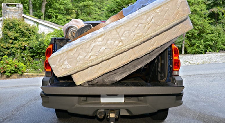 A truck with bedding on the back.