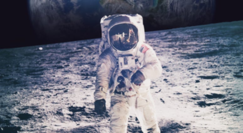 Astronaut walking on moon with earth in background. Elements of this image furnished by NASA