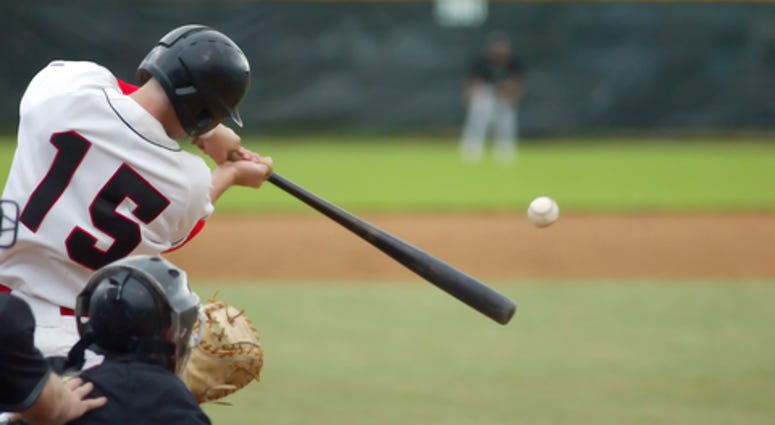 Baseball player number 15 connecting with baseball,
