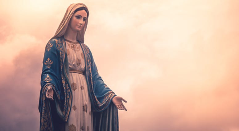 Virgin Mary statue at Catholic church with sunlight in cloudy day background,