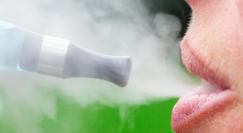 Woman inhaling from an electronic cigarette - stock photo. (iStock / Getty Images Plus)